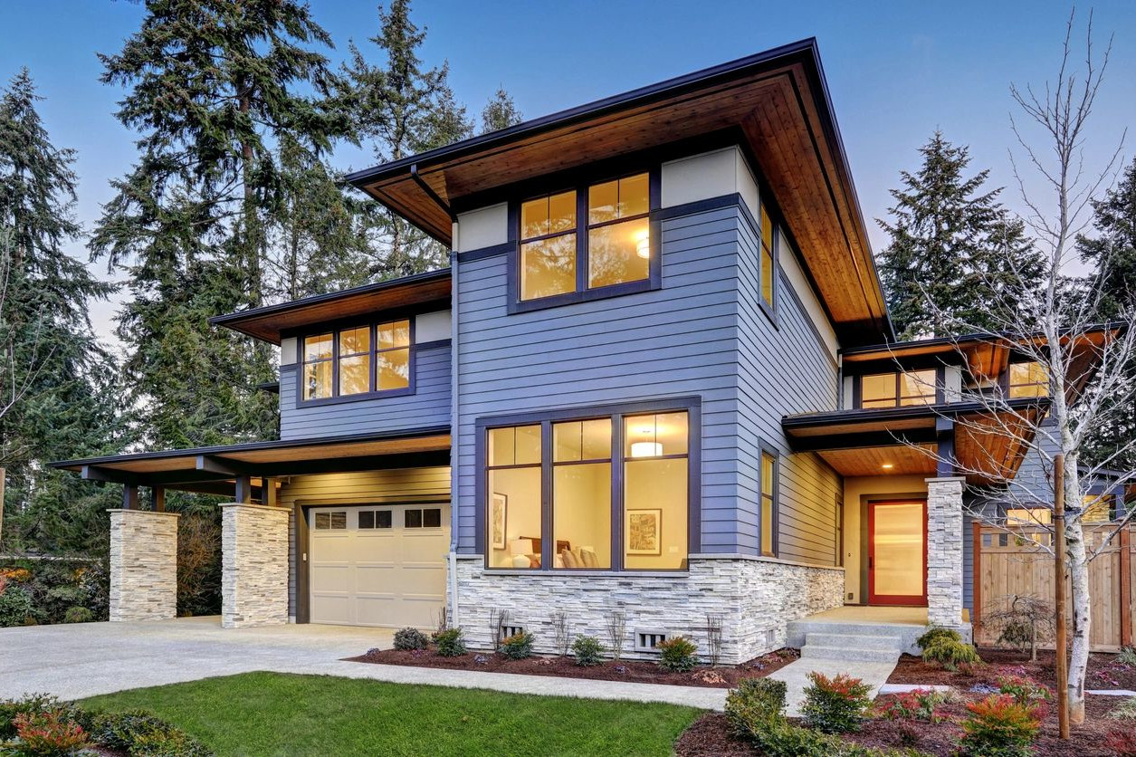 A blue house with a stone driveway and garage.